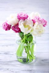 Bouquet of fresh roses and tulips on wooden background