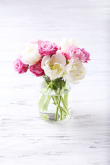 Bouquet of fresh roses and tulips on wooden background