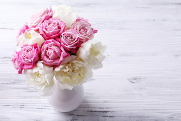 Bouquet of fresh roses and tulips on wooden background