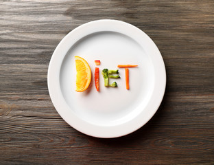 Word DIET made of sliced vegetables in plate