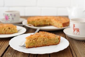 Old fashioned apple pie, cut, on white plate with teaware