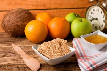 Bowl with sesame biscuits between wooden spoon and towel