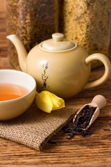 Tulip bloom next to oriental tea set on jute cloth