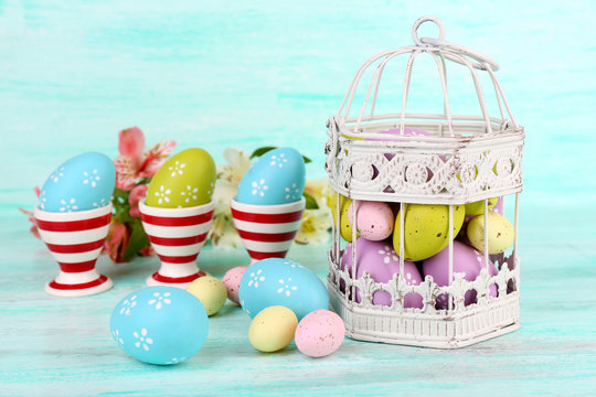 Easter composition with Easter eggs in decorative cage and