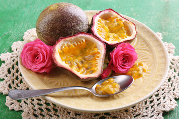 Passion fruit on plate on color wooden background