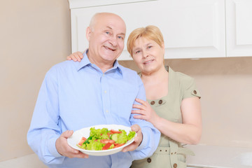 Couple holds a plate with salad