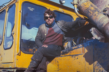 Fototapeta na wymiar Young soviet tractor driver having short rest