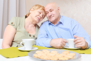 Couple has tea with biscuits