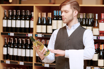 Sommelier in the store near shelves