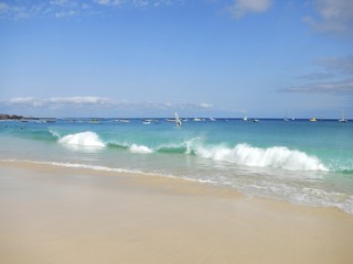 Waves breaking on tropical beach with white sand