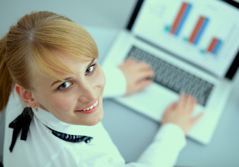 Portrait of  businesswoman sitting at  desk with a laptop