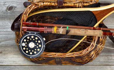 Creel filled with trout fishing equipment - obrazy, fototapety, plakaty