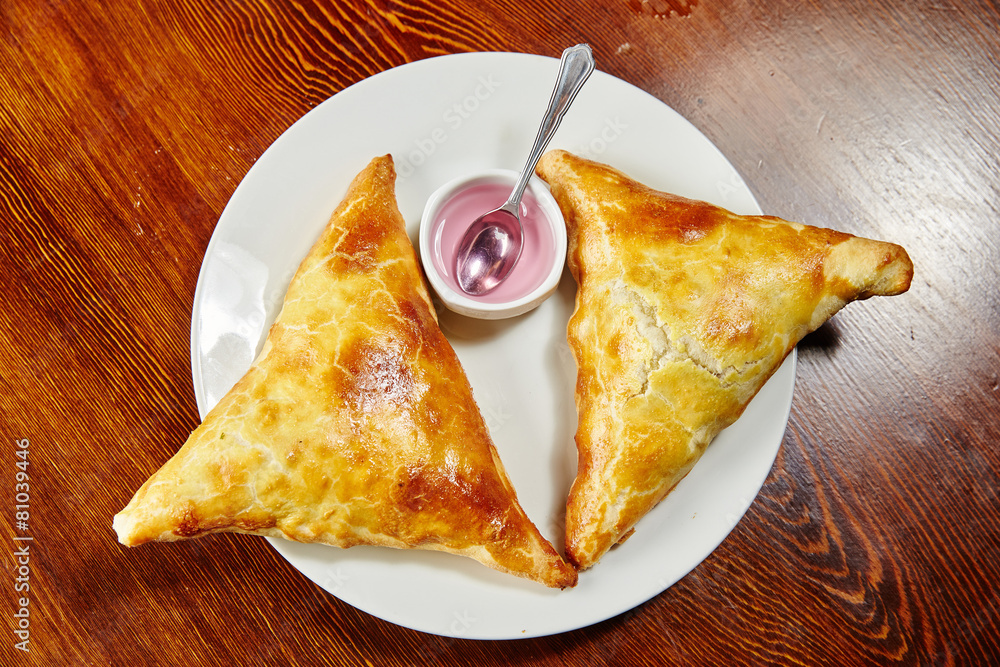 Wall mural Uzbek national dish samosa, two pieces lie on a white plate, vin