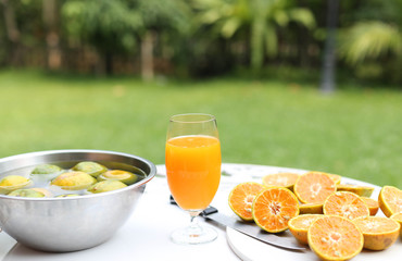 Glass of freshly pressed orange juice with sliced orange half on