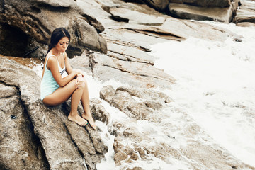 Young woman in a swimsuit sitting on the shore