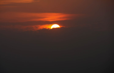 Fototapeta na wymiar Sun in an orange sky with dark clouds