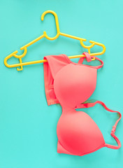 Summer concept, bra on coat hanger on blue. (Pop art style)