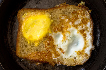 Toast with scrambled eggs in a frying pan
