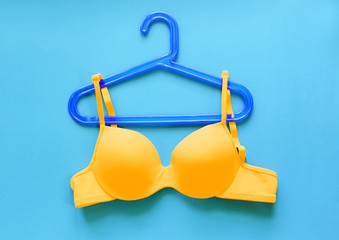 Summer concept, bra on coat hanger on blue. (Pop art style)