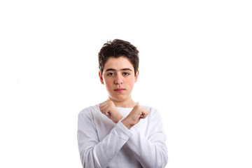 Crossing fists gesture by Caucasian boy with acne-prone skin.