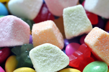 Sour jelly pink, orange and white candy on colored smarties
