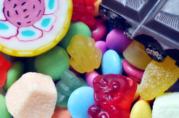 Fototapeta na wymiar Lollipop, gummy bears, chocolate and sour candy on smarties