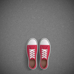 Vintage sneakers stand on asphalt.