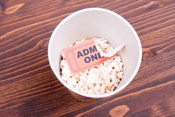 half cup of popcorn, used ticket on the table top view