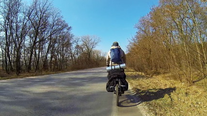 Man cycling on road in countryside.