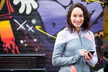 Young attractive woman adjust her music player before running