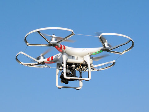 Drone quadcopter with digital camera in flight.