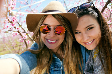 Two beautiful young women taking a selfie in the field.