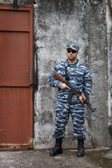 Caucasian military man with black sunglasses in urban warfare ho