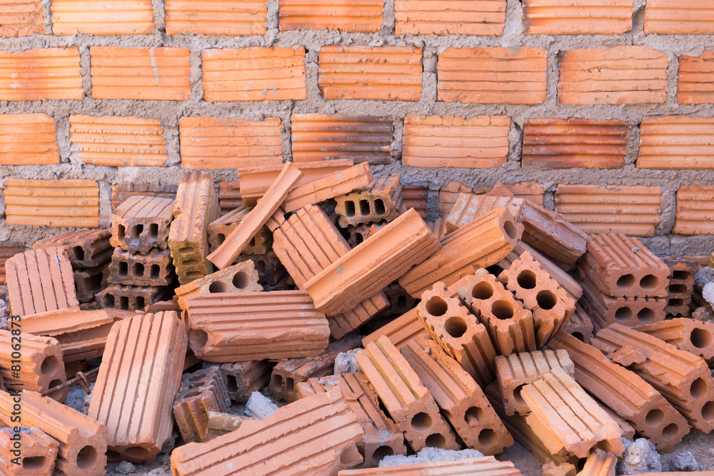 Canvas Prints pile of bricks in construction site with brick wall background