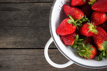 Sweet ripe strawberries in rustic colander