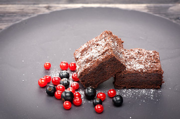 Chocolate brownies with berries and icing sugar