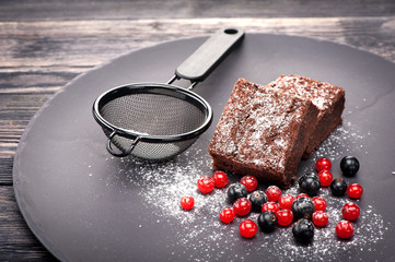 Chocolate brownies with berries and icing sugar