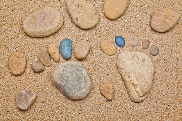 Fototapeta na wymiar Stone foot in the sand