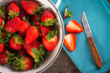 Fresh just clean wet strawberries in rustic colander