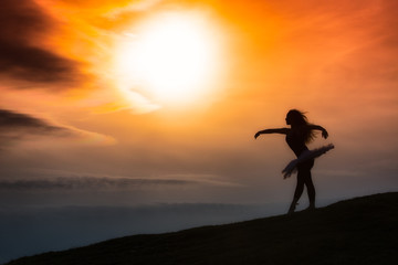 Ballerina silhouette, dancing alone in nature in the mountains a