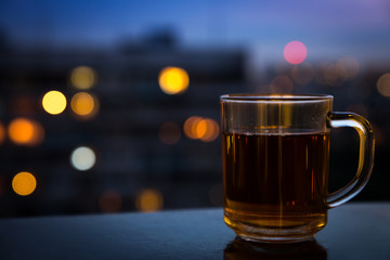 Tea cup in front of night city lights