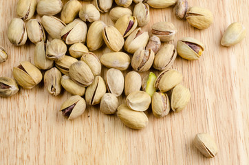 roasted and salted pistachios on wooden background