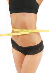 Girl measuring her waist with tape measure