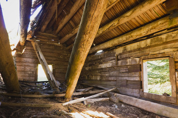 Fototapeta na wymiar Collapsed log beams in old cabin