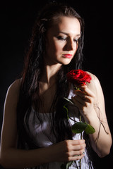 Sensual young woman with a red rose