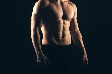 Close up of sports man's muscular isolated on black background