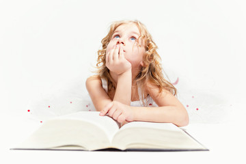 Obraz na płótnie Canvas Красивая маленькая девочка думает о прочитанном в книге.