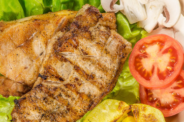 Grilled meat dish with tomato, potatoes and mushrooms