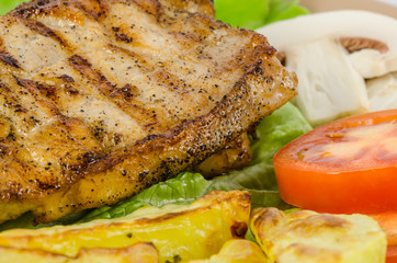 Grilled meat dish with tomato, potatoes and mushrooms
