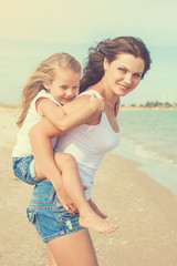 Mother and her daughter  having fun on the beach